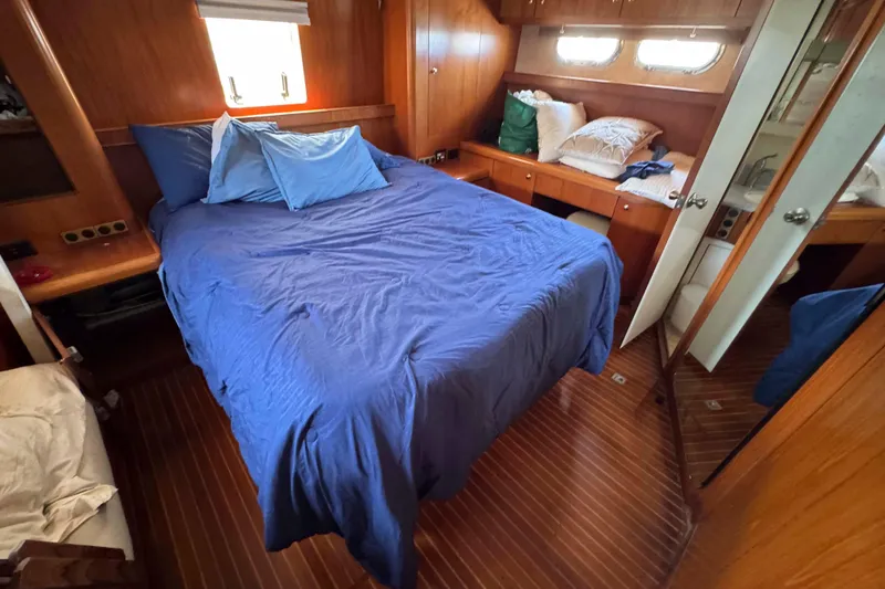 Slide: The Image of Cozy cabin interior of 2000 Horizon E56 yacht with blue bedding and wooden decor. - 30