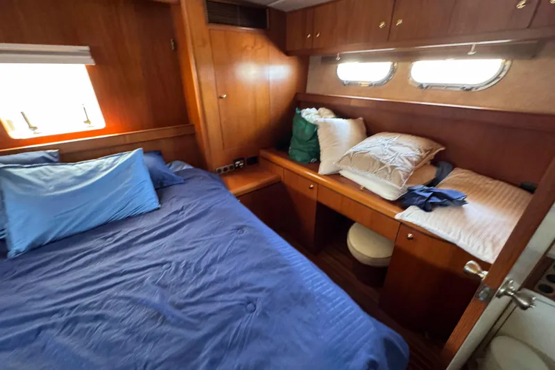 Slide: The Image of Cozy cabin interior of 2000 Horizon E56 yacht with wooden furnishings and blue bedding. - 31