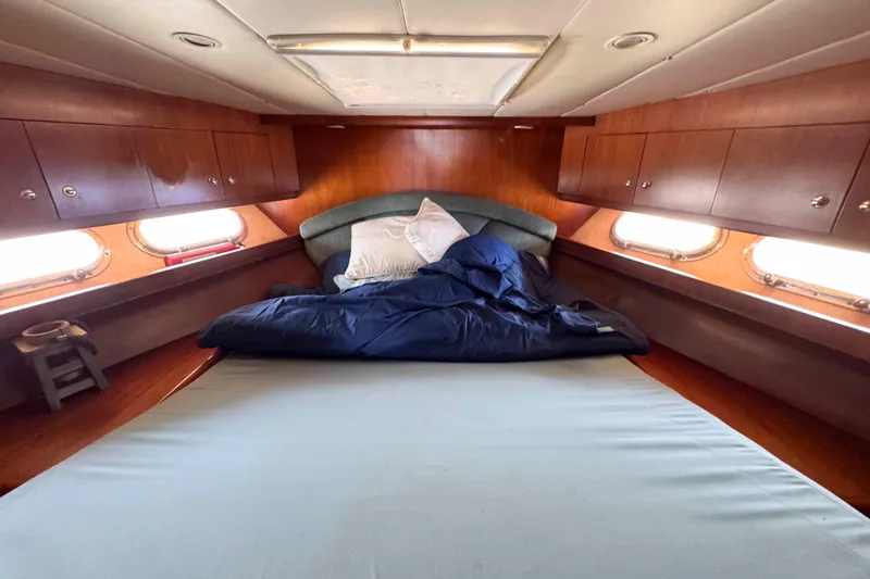 Slide: The Image of Cozy cabin bedroom in 2000 Horizon E56 yacht with wooden cabinets and porthole windows. - 44
