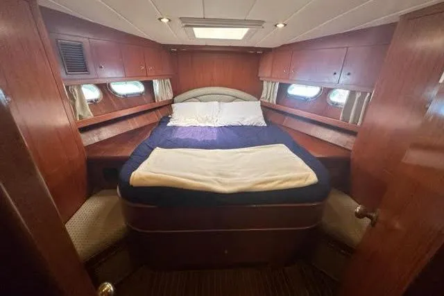 Slide: The Image of Cozy cabin interior of 2000 Horizon E56 yacht with wood paneling and bed. - 52