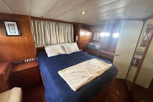 Slide: The Image of Luxurious cabin interior of 2000 Horizon E56 yacht with cozy bed and wooden decor. - 56
