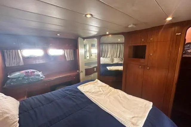 Slide: The Image of Luxurious cabin interior of 2000 Horizon E56 yacht with wood paneling and cozy bedding. - 57