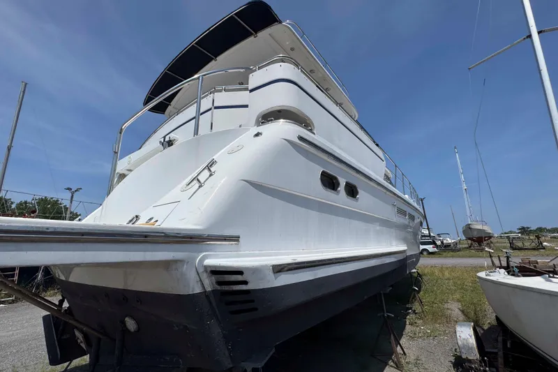 Slide: The Image of Large white Horizon E56 yacht from 2000, docked on land under clear blue sky. - 7