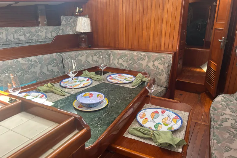 Slide: The Image of Interior of 1980 Hans Christian 43 yacht with elegant dining setup and wooden furnishings. - 15
