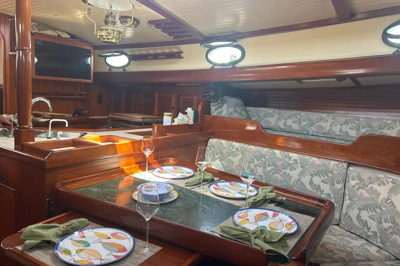 Slide: The Image of Interior of 1980 Hans Christian 43 sailboat with elegant dining setup and wooden finishes. - 16