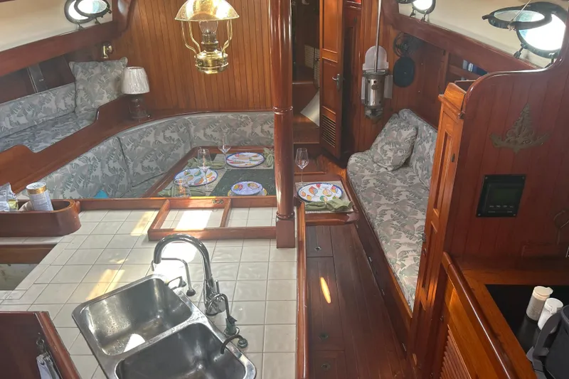 Slide: The Image of Interior of 1980 Hans Christian 43 sailboat with wood paneling and cozy seating area. - 18