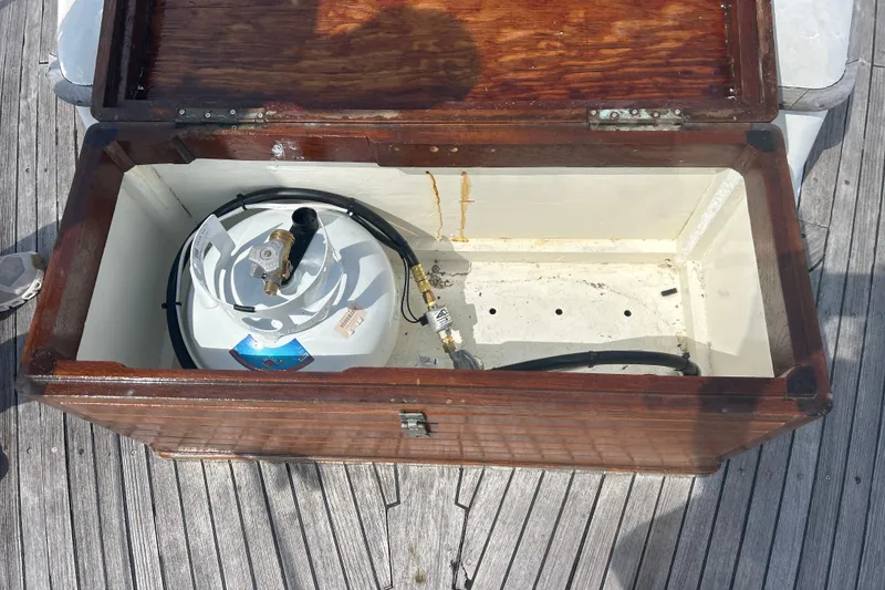 Slide: The Image of Open wooden storage compartment on 1980 Hans Christian 43 yacht, containing a propane tank. - 27