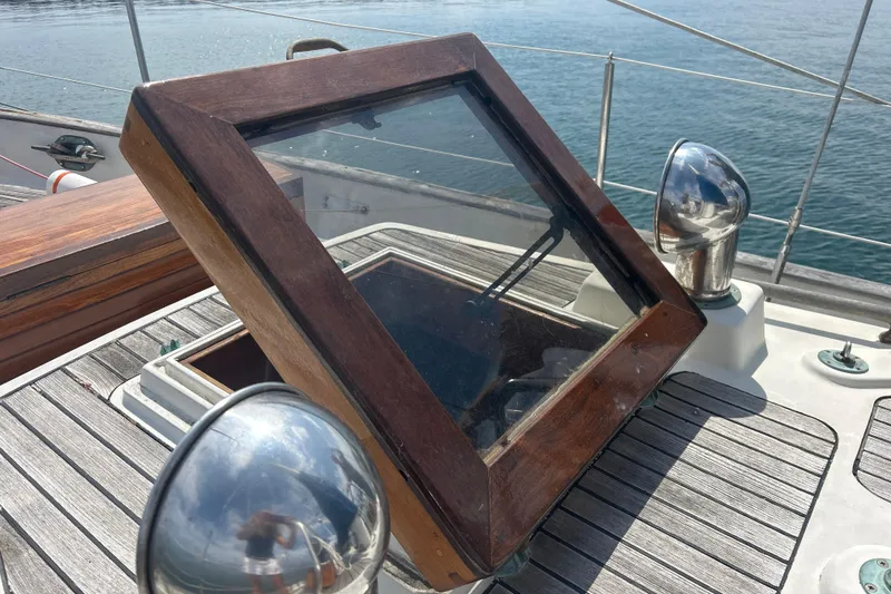Slide: The Image of Wooden hatch on 1980 Hans Christian 43 sailboat deck, overlooking calm water. - 28