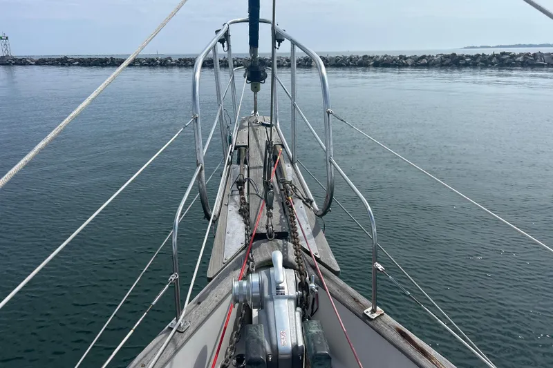 Slide: The Image of Bow view of 1980 Hans Christian 43 sailboat on calm water near rocky breakwater. - 29