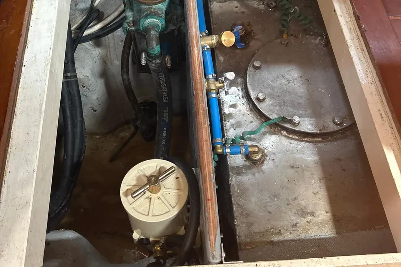 Slide: The Image of Engine compartment of a 1980 Hans Christian 43 sailboat, showing mechanical components and piping. - 37