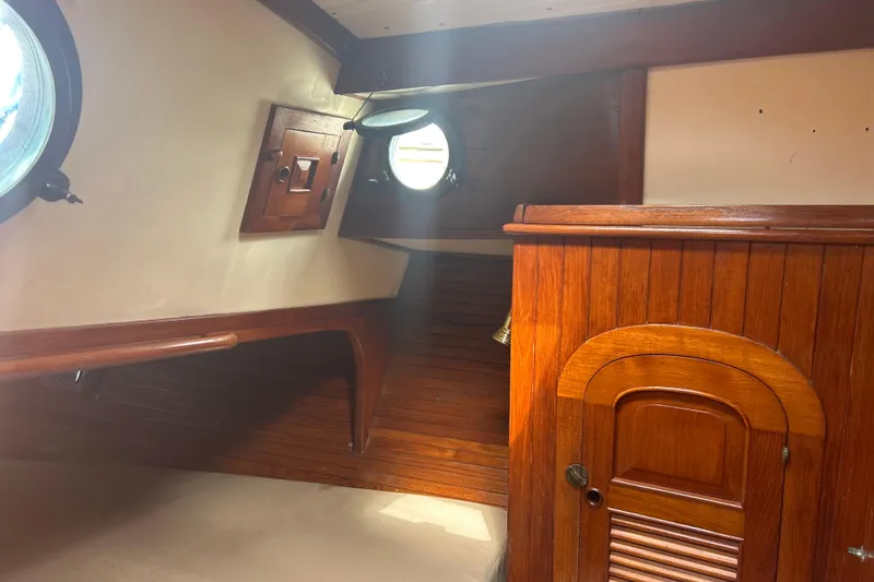 Slide: The Image of Interior of 1980 Hans Christian 43 sailboat with wooden paneling and porthole window. - 38