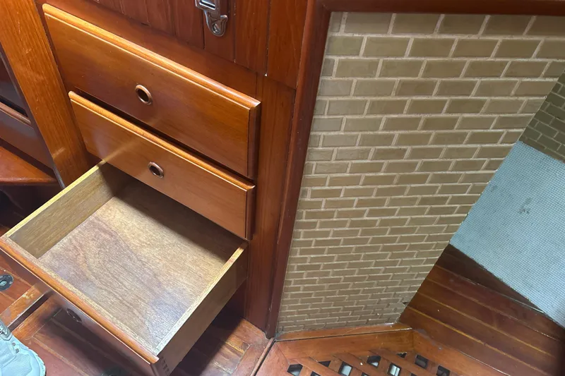 Slide: The Image of Open wooden drawer in 1980 Hans Christian 43 sailboat interior with brick-patterned wall. - 44