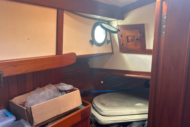 Slide: The Image of Interior of 1980 Hans Christian 43 sailboat with wooden paneling and porthole. - 47