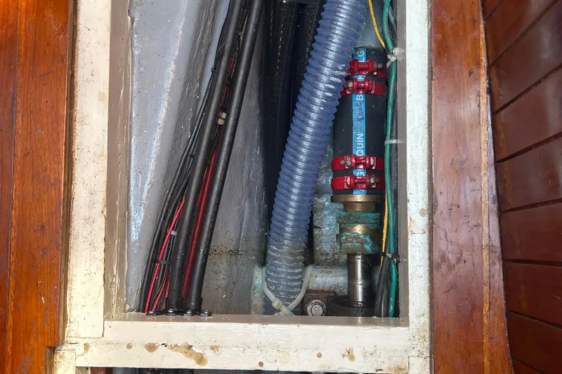 Slide: The Image of Engine compartment of a 1980 Hans Christian 43 sailboat, showing hoses and wiring. - 49
