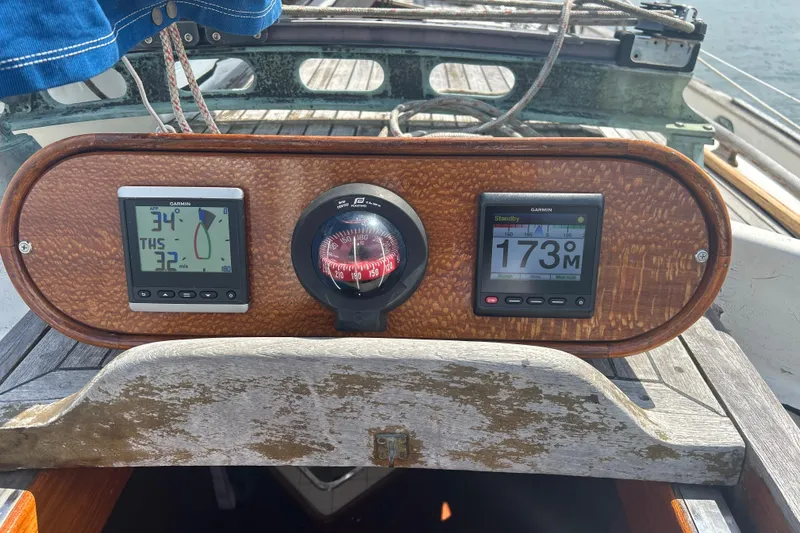 Slide: The Image of Cockpit instruments on a 1980 Hans Christian 43 sailboat, featuring Garmin displays and a compass. - 52
