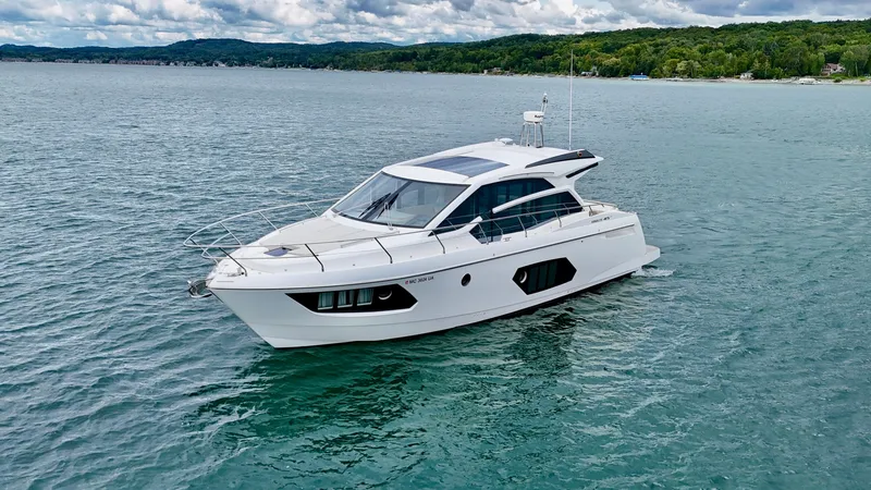 Slide: The Image of 2016 Absolute Sport Yacht cruising on a serene lake with lush green shoreline. - 15