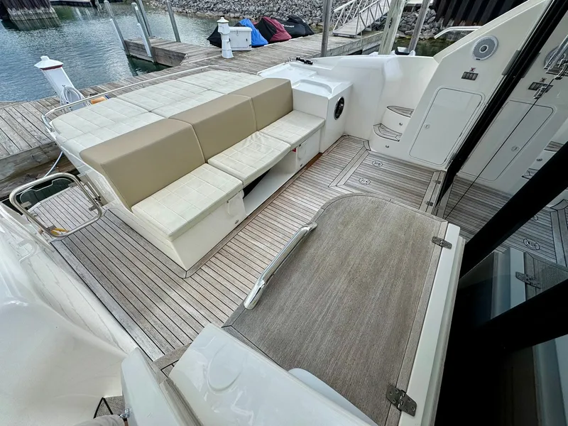 Slide: The Image of 2016 Absolute Sport Yacht interior with beige seating and wooden deck at a marina. - 26