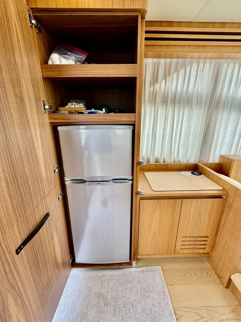 Slide: The Image of Interior of a 2016 Absolute Sport Yacht featuring a compact kitchen with a fridge. - 42
