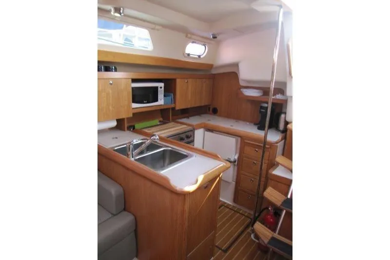 Slide: The Image of Interior of 2004 Catalina 350 MkII yacht featuring a compact kitchen area. - 10