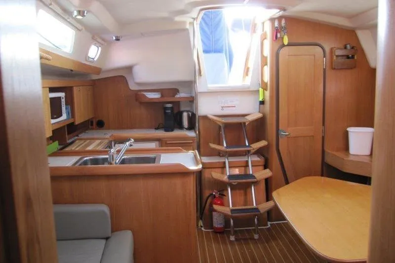 Slide: The Image of Interior of a 2004 Catalina 350 MkII sailboat with wooden cabinetry and compact kitchen. - 18