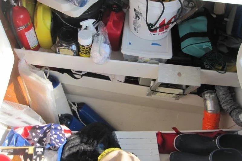 Slide: The Image of Storage compartment of a 2004 Catalina 350 MkII sailboat, filled with various supplies and equipment. - 43