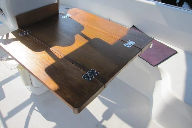 Slide: The Image of Wooden cockpit table on a 2004 Catalina 350 MkII sailboat, with sunlight casting shadows. - 45