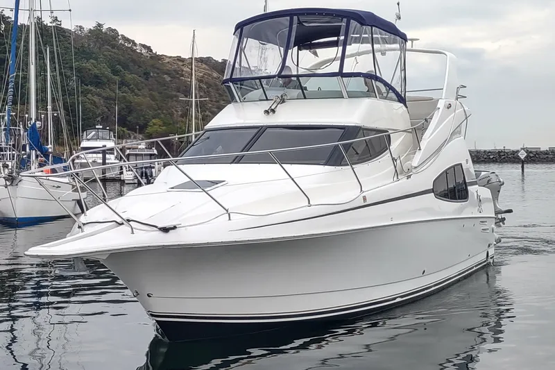 The Image of 2003 Silverton 330 Sport Bridge yacht docked in a marina, featuring sleek design and spacious deck. - 0