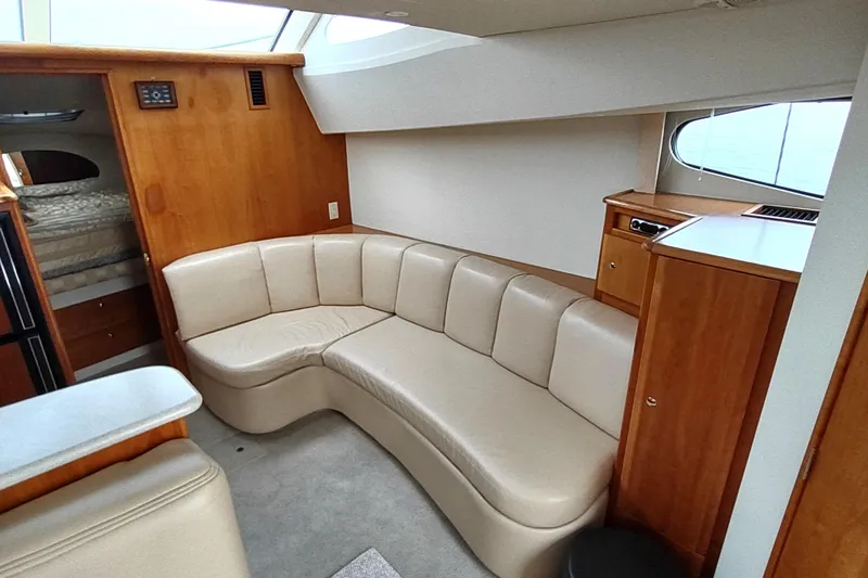 Slide: The Image of 2003 Silverton 330 Sport Bridge interior with beige seating and wooden cabinetry. - 13