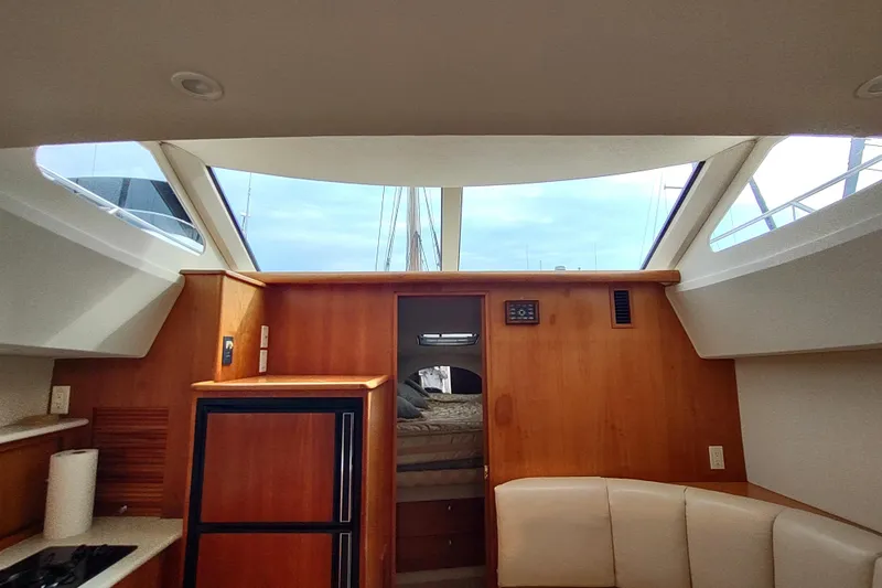 Slide: The Image of Interior of 2003 Silverton 330 Sport Bridge yacht with wood paneling and seating. - 14