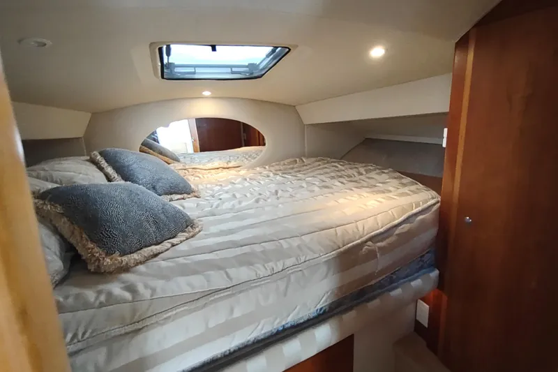 Slide: The Image of Cozy bedroom interior of 2003 Silverton 330 Sport Bridge yacht with skylight and plush bedding. - 20