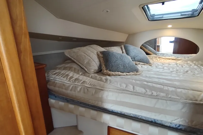 Slide: The Image of Interior cabin of 2003 Silverton 330 Sport Bridge with cozy bedding and pillows. - 21