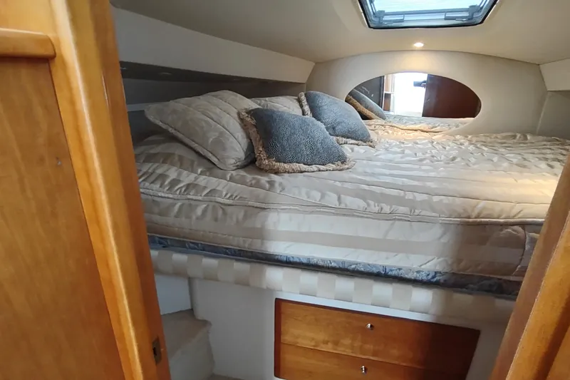 Slide: The Image of Cozy cabin interior of 2003 Silverton 330 Sport Bridge with plush bedding and pillows. - 22