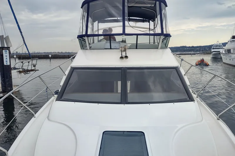 Slide: The Image of 2003 Silverton 330 Sport Bridge yacht docked at marina, overcast sky. - 29