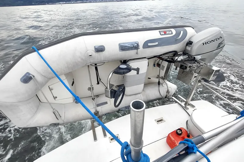 Slide: The Image of 2003 Silverton 330 Sport Bridge with inflatable dinghy and Honda outboard motor on water. - 31