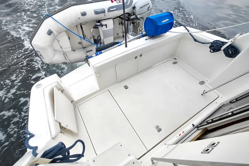 Slide: The Image of 2003 Silverton 330 Sport Bridge boat deck with inflatable dinghy and Honda motor. - 32