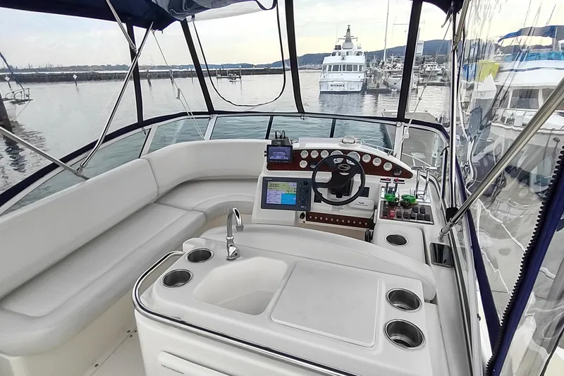 Slide: The Image of 2003 Silverton 330 Sport Bridge helm with modern navigation equipment, docked at marina. - 34
