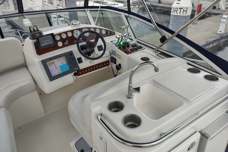 Slide: The Image of 2003 Silverton 330 Sport Bridge boat interior with steering, navigation, and sink area. - 35