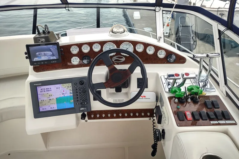 Slide: The Image of 2003 Silverton 330 Sport Bridge helm with navigation equipment and control panel. - 36
