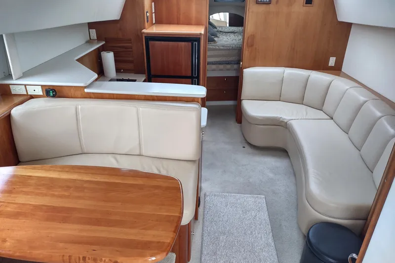 Slide: The Image of Interior of 2003 Silverton 330 Sport Bridge with beige seating and wooden accents. - 9