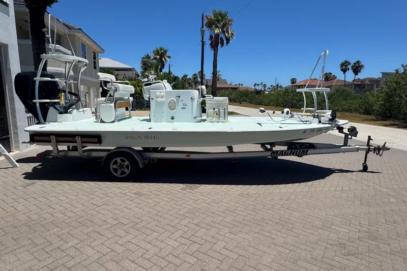 Slide: The Image of 2007 NewWater Ibis boat on trailer, parked outdoors under clear blue sky. - 1