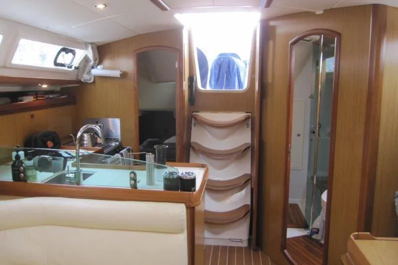 Slide: The Image of Interior of 2008 Jeanneau Sun Odyssey 39i yacht, featuring kitchen and seating area. - 13