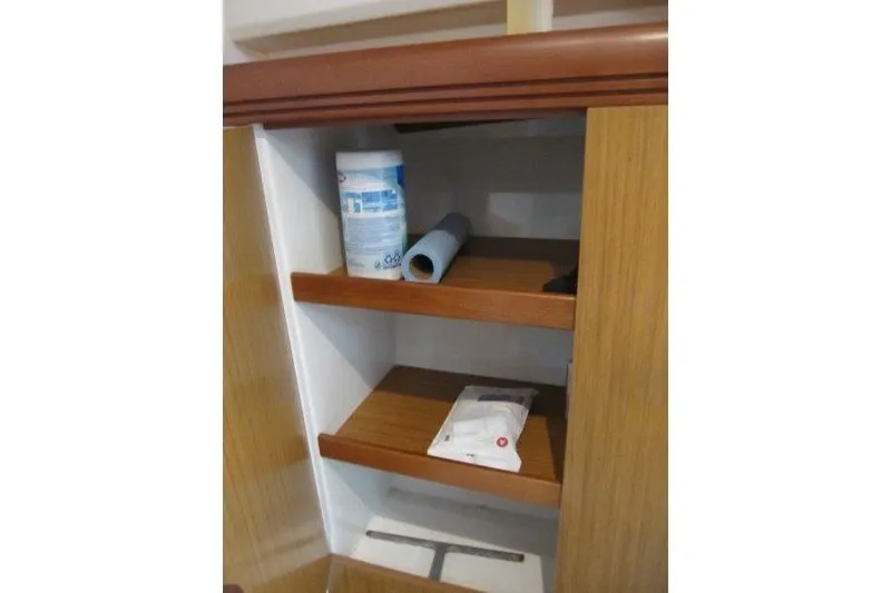 Slide: The Image of Wooden cabinet shelves on Jeanneau Sun Odyssey 39i yacht, 2008 model, with cleaning supplies. - 17