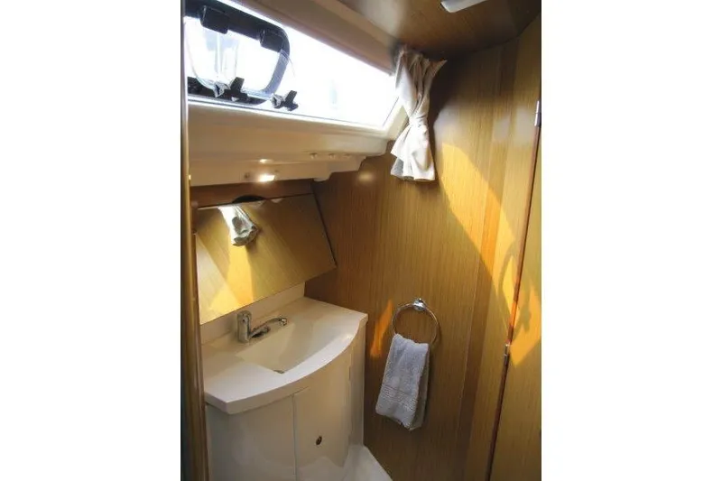 Slide: The Image of Compact bathroom in 2008 Jeanneau Sun Odyssey 39i yacht with wooden finish and natural light. - 18