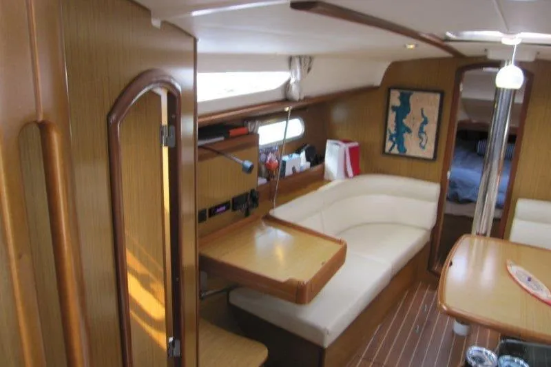 Slide: The Image of Interior of 2008 Jeanneau Sun Odyssey 39i sailboat with wood finish and seating area. - 2