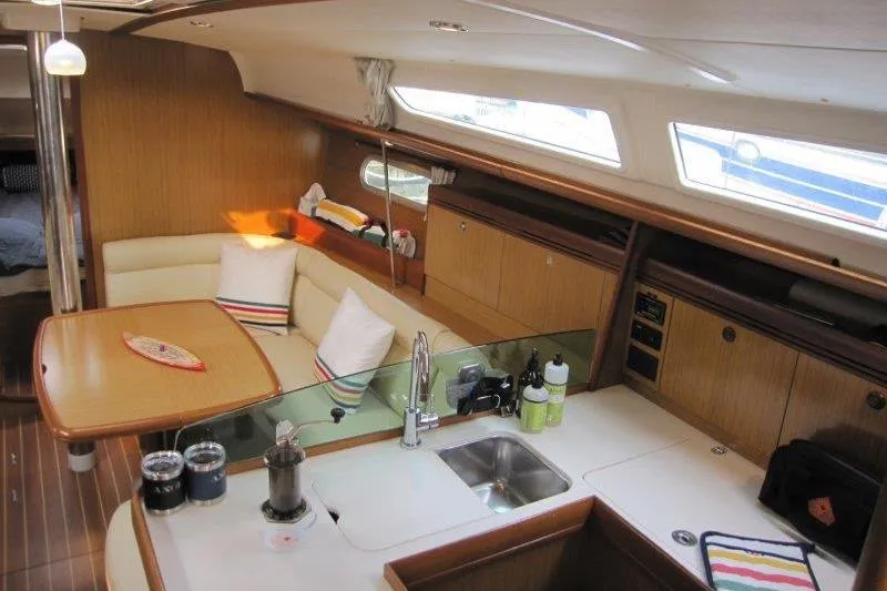 Slide: The Image of Interior of 2008 Jeanneau Sun Odyssey 39i yacht with modern kitchen and cozy seating area. - 3