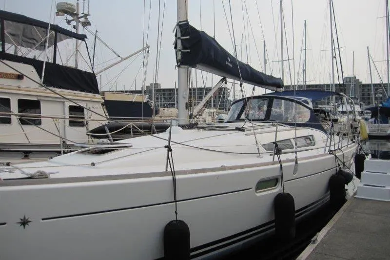 Slide: The Image of 2008 Jeanneau Sun Odyssey 39i sailboat docked in a marina, surrounded by other boats. - 34