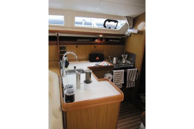 Slide: The Image of Interior of 2008 Jeanneau Sun Odyssey 39i yacht, featuring a compact kitchen area. - 4