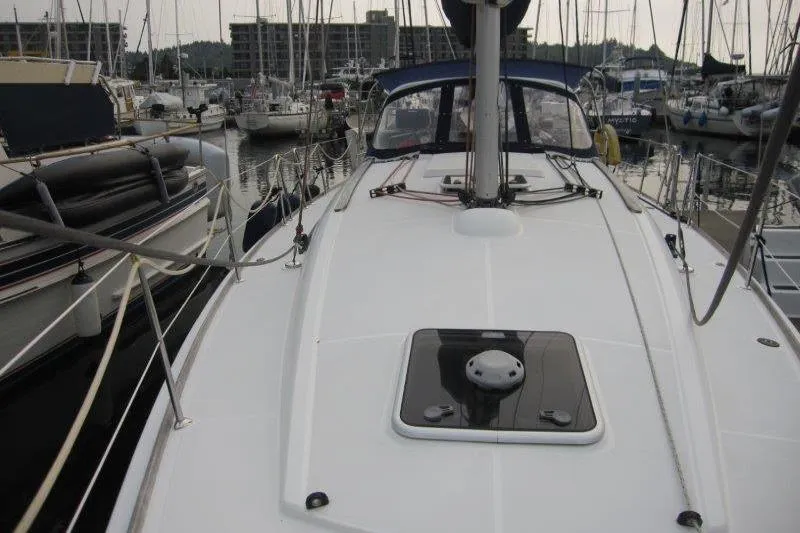 Slide: The Image of 2008 Jeanneau Sun Odyssey 39i sailboat docked in a marina, showcasing its sleek deck design. - 46