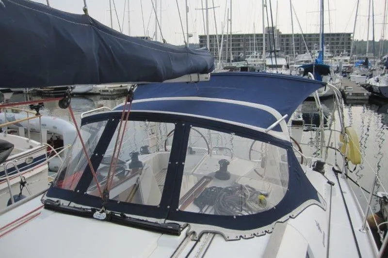 Slide: The Image of 2008 Jeanneau Sun Odyssey 39i sailboat docked in marina, featuring blue canopy and clear windows. - 47