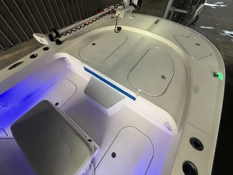 Slide: The Image of 2020 Tideline 235 Hybrid boat interior with storage compartments and seating, illuminated by blue LED lights. - 12
